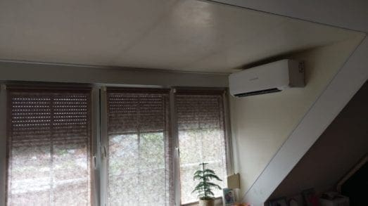 Airco binnenunit in zijkant van dakkapel geplaatst.