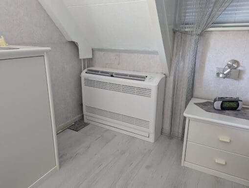 vloermodel binnenunit in slaapkamer onder schuin dak